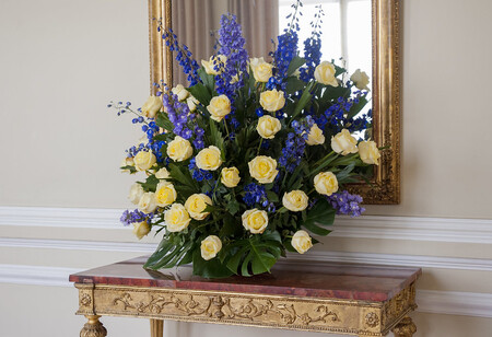 A vibrant bouquet of yellow flowers on a table in a hallway.