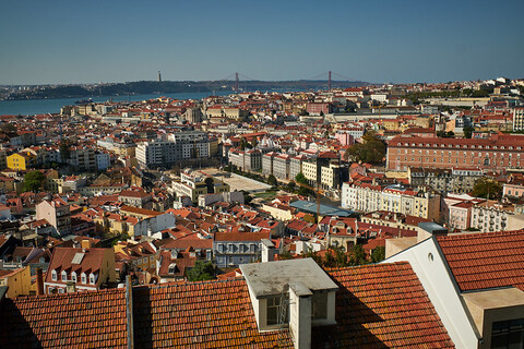 A beautiful, sunny day in the city of Lisbon, with a clear view of the buildings and a blue sky.