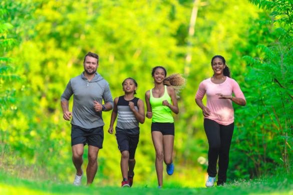 a group of 4 people are running  for exercise in a wooded area