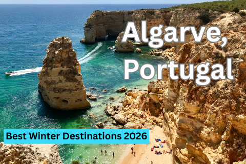 A scenic view of a rocky coastline with clear turquoise water, a sandy beach with people sunbathing, and boats sailing on the sea.