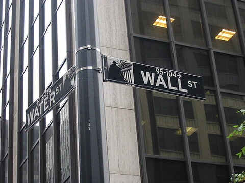 A black and white street sign that reads Wall St.