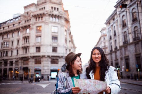 Two tourists in an old city looking at a map.