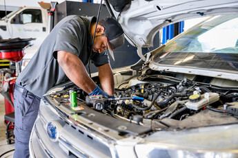 A man working on the engine of a car.