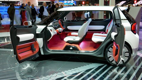 A white sports car with red seats and a futuristic design.