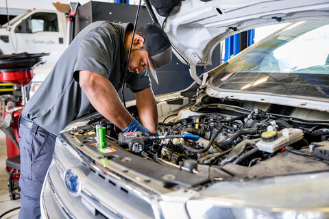 A man working on the engine of a car.