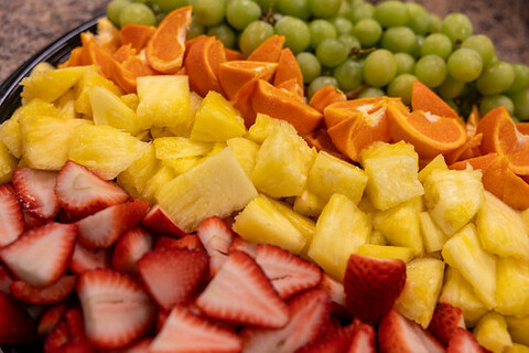 A black bowl full of various fruits.
