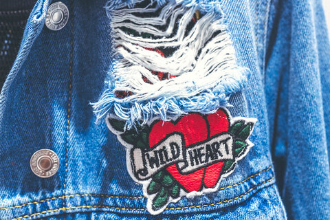 A blue denim jacket with a patch on the front.