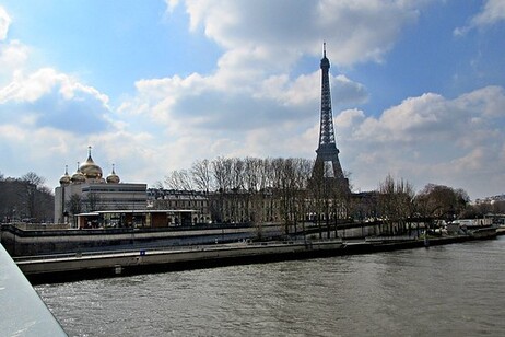 A boat travels through the water near the Eiffel Tower.