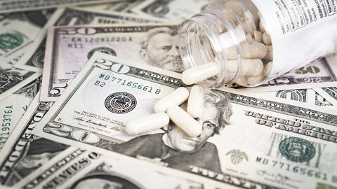 An open jar of pills spilling onto a pile of money