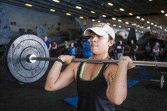 A woman lifting weights inside a gym.
