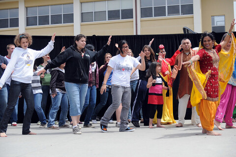 A group of people performing a dance together, wearing matching outfits.