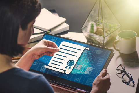 A woman views a virtual degree on her laptop screen.