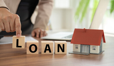 The word "LOAN" is displayed on the table with blocks.