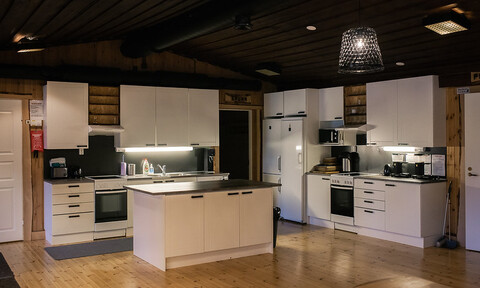 A white kitchen with a wood floor and white cabinets.
