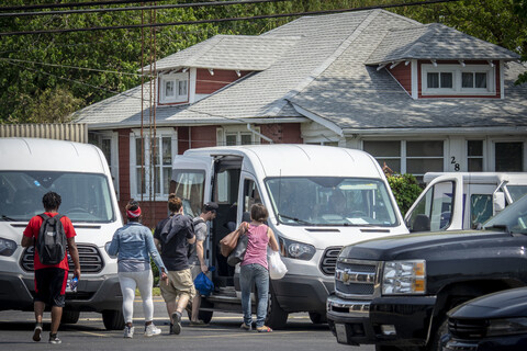 The group is posing in front of a blue van.