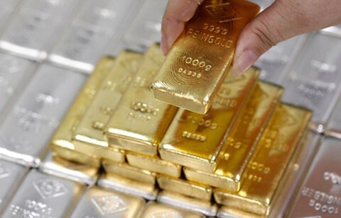 Gold nuggets are being sorted by a person who is examining them.